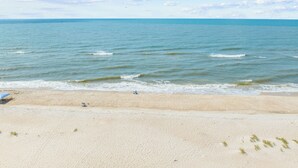 Une plage avec un ciel dégagé et une mer calme.