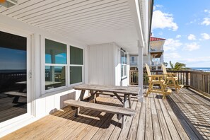 A wooden deck with picnic tables and chairs, overlooking the ocean. - Sugar Magnolia: Beachfront SGI Home- Sleeps 12, Priv. Pool, Pet Friendly! (St. George Island)
