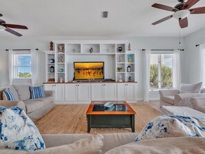 A living room with a TV, white cabinets, and two sofas.