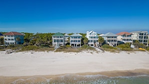 A beachfront property with multiple buildings, a sandy beach, and ocean waves.