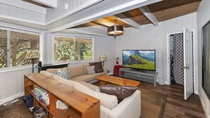 Un salón amplio con un sofá grande, una mesa de centro de madera y un televisor.