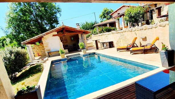Une piscine rectangulaire dotée d’une terrasse en bois et de chaises longues.