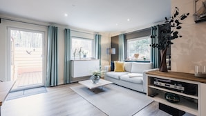 Ein modernes Wohnzimmer mit Sofa, Couchtisch und Unterhaltungseinheit.
