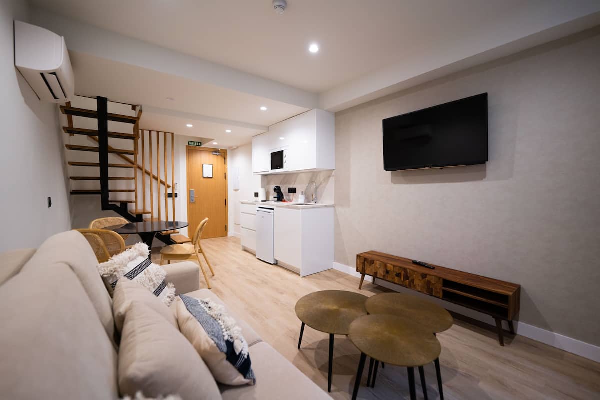 Un salon moderne avec un canapé, une table basse et un téléviseur fixé au mur.