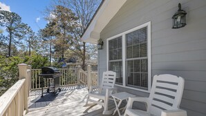 A wooden deck with a grill, two white chairs, and a table. - Beach house w/ FREE Golf Cart & Fire Pit! (Pawleys Island)
