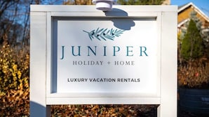 Letrero de Juniper Holiday + Home, alquileres vacacionales de lujo.