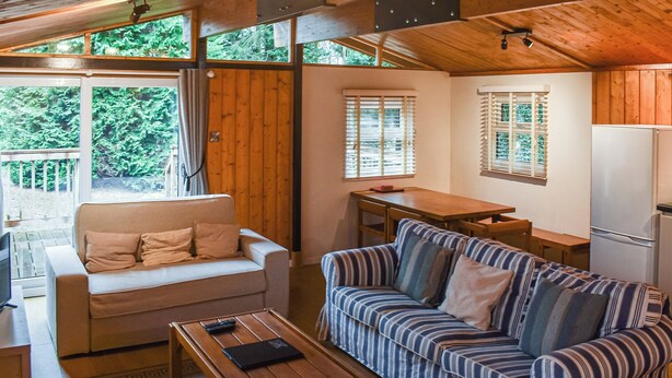 A cozy cabin interior with a sofa, a dining table, and a kitchen area. - 2 bedroom accommodation in Charlcot, near Masham (Charlcot, near Masham)