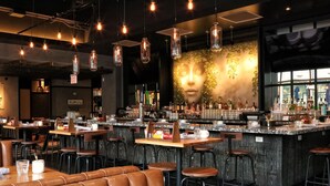A bar area with stools, a counter with bottles, and a wall with a leafy design. - Sentral Michigan Avenue (Chicago)