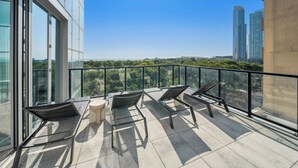 A balcony with a glass railing, a table, and four chairs. - Sentral Michigan Avenue (Chicago)