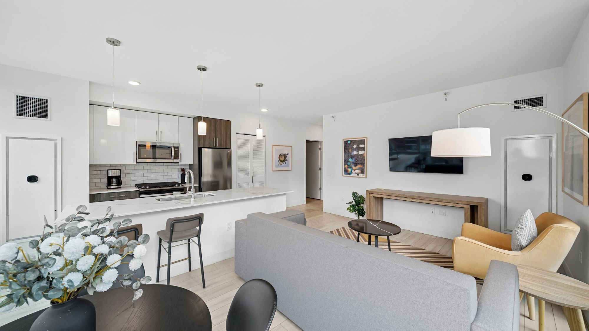 A modern apartment with a kitchen, dining area, and living room.