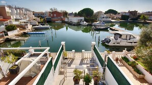 Un port esportiu amb embarcacions amarrades, una zona de pont cobert i edificis residencials als voltants.