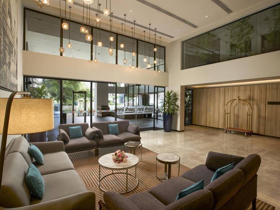 A spacious lobby with a high ceiling, modern lighting, and comfortable seating arrangements.