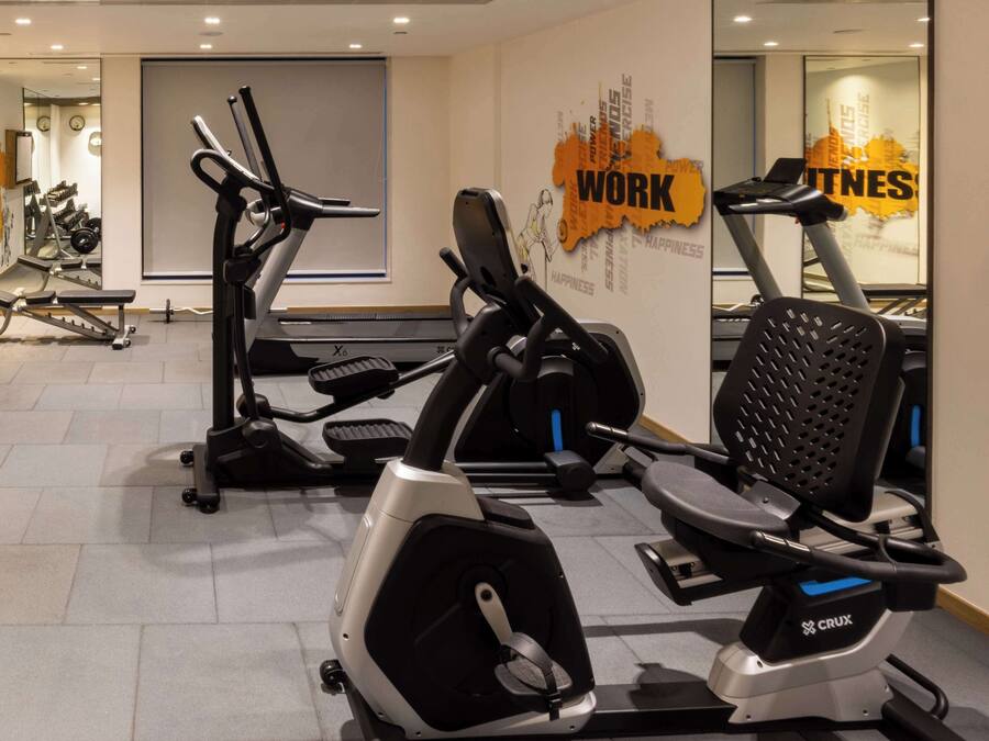 A gym with various exercise equipment including treadmills and stationary bikes.