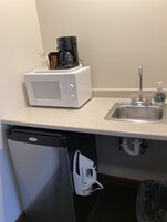 Coffee/tea maker, fridge, microwave, dining table