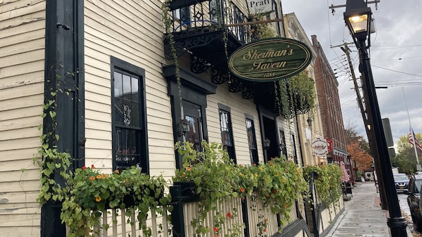 A building with a sign for 'Sherman's Tavern' and 'The Hotel Pratt'. - Hotel Pratt- Cooperstown, NY- Baseball Central- Downtown- (Cooperstown)