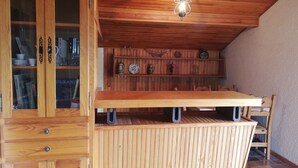 Una cocina de madera con mesa, armarios y una lámpara colgante.