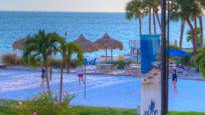 Blick auf einen Strand mit Pool, Palmen und einem Schild für Sailport.