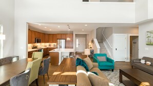 A spacious living area with a kitchen, dining table, and sofas.