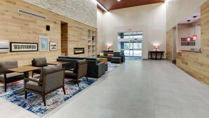 A spacious lobby with a fireplace, seating area, and a reception desk.