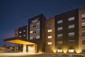 A multi-story hotel with a prominent 'Country Inn & Suites' sign, a covered entrance, and a parking lot.