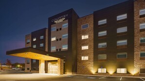 A multi-story hotel with a prominent 'Country Inn & Suites' sign, a covered entrance, and a parking lot.
