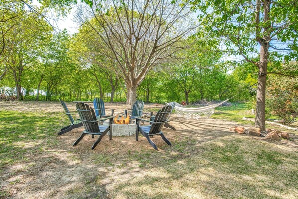 Un espace extérieur aménagé avec des chaises Adirondack et un foyer.