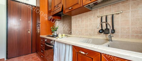 A kitchen with wooden cabinets, a sink, and a stove.