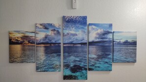 A wall-mounted canvas with a seascape painting.