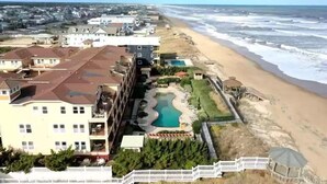 Un hôtel situé sur la côte, doté d’une piscine, d’un accès à la plage et offrant une vue sur l’océan.