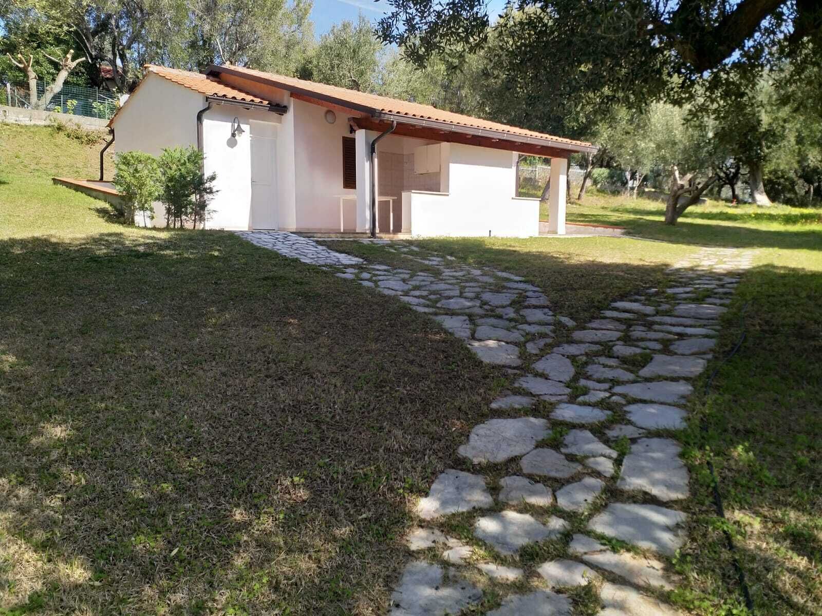 A small, single-story building with a tiled roof and a stone pathway leading to the entrance.