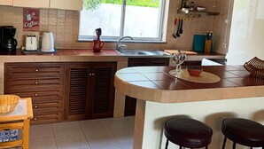 Una cucina moderna con una grande finestra, un angolo caffè e un bancone con sgabelli.