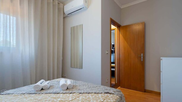 Una camera d'albergo con un letto, un armadio e una porta che dà su un bagno.