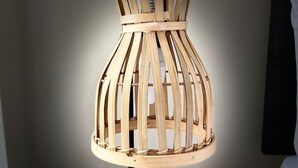 A wooden lamp with a black base on a bedside table. - The Gateway Apartment 3 (Blackpool)