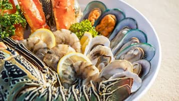 Een visplateau met diverse schelpdieren en zalm, versierd met citroenpartjes en peterselie.