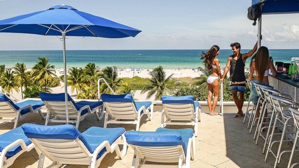 A beachside lounge area with lounge chairs and a bar. - Boutique Suite with Ocean View and Rooftop Pool (Miami Beach)