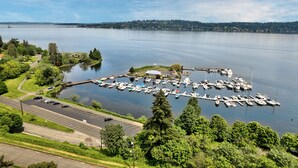 An aerial view of a marina with boats docked, a parking lot, and a road leading to the marina. - 4bd w/ Lake Views and Chef's Kitchen (Seattle)