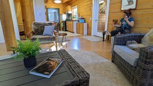 A cozy cabin interior with a living area, kitchen, and dining space.
