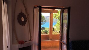 Una habitación con chimenea, vistas al mar y un balcón con barandilla de madera.