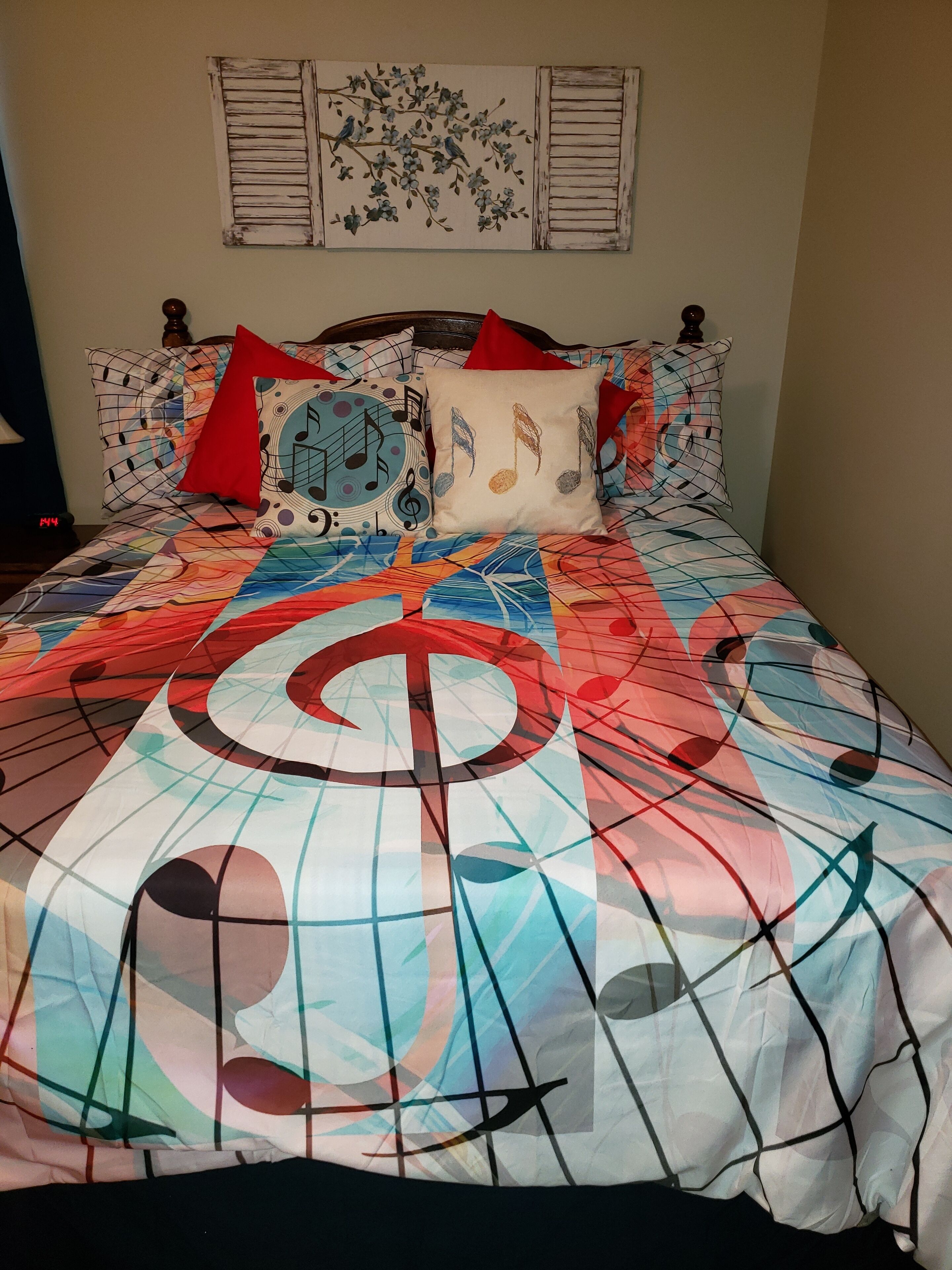 Un lit avec une couvre-lit colorée ornée de notes de musique et d’un grand symbole de clé de sol.