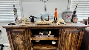 Een houten kast met planken, een klein beeldje en decoratieve objecten.