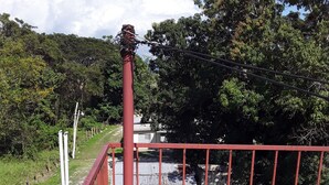 A red metal fence with a concrete staircase leading to a building with a corrugated metal roof. - Royal Savanna Inn Hotel (Savanna la Mar)