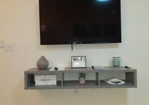 Relax in this stylish living room with a flat-screen TV, console table, and comfortable seating area.