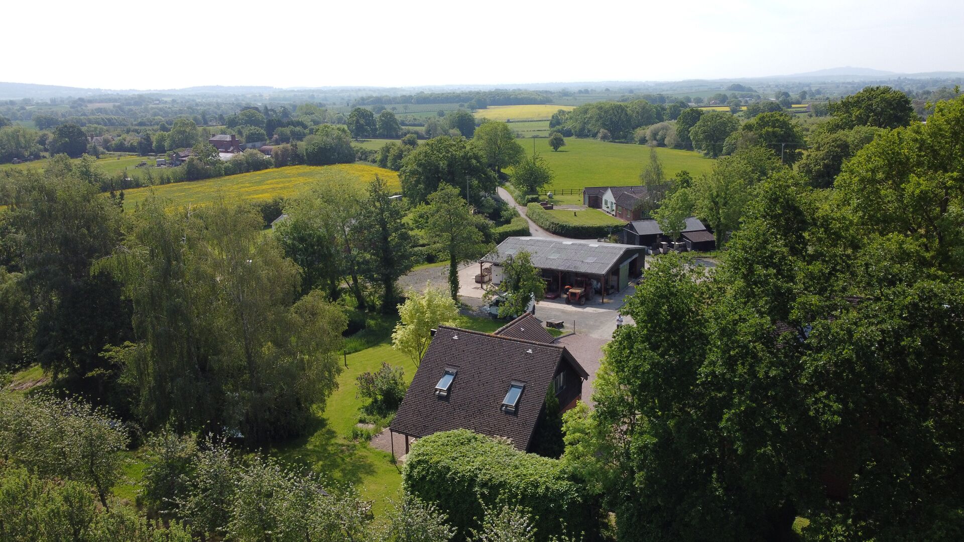 A rural property with a large house, a barn, and surrounding fields.