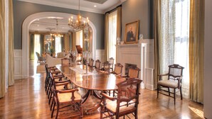 Un comedor formal con una gran mesa de madera, varias sillas y un candelabro.