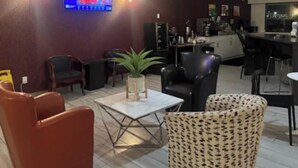 A lobby with seating, a TV screen, and a bar area. - Ramada by Wyndham Nisku (Nisku)