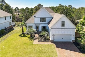 A two-story house with a garage, surrounded by a well-maintained lawn and palm trees. - 30A! Minutes to Beach! Best Pool Access! Games (Santa Rosa Beach)