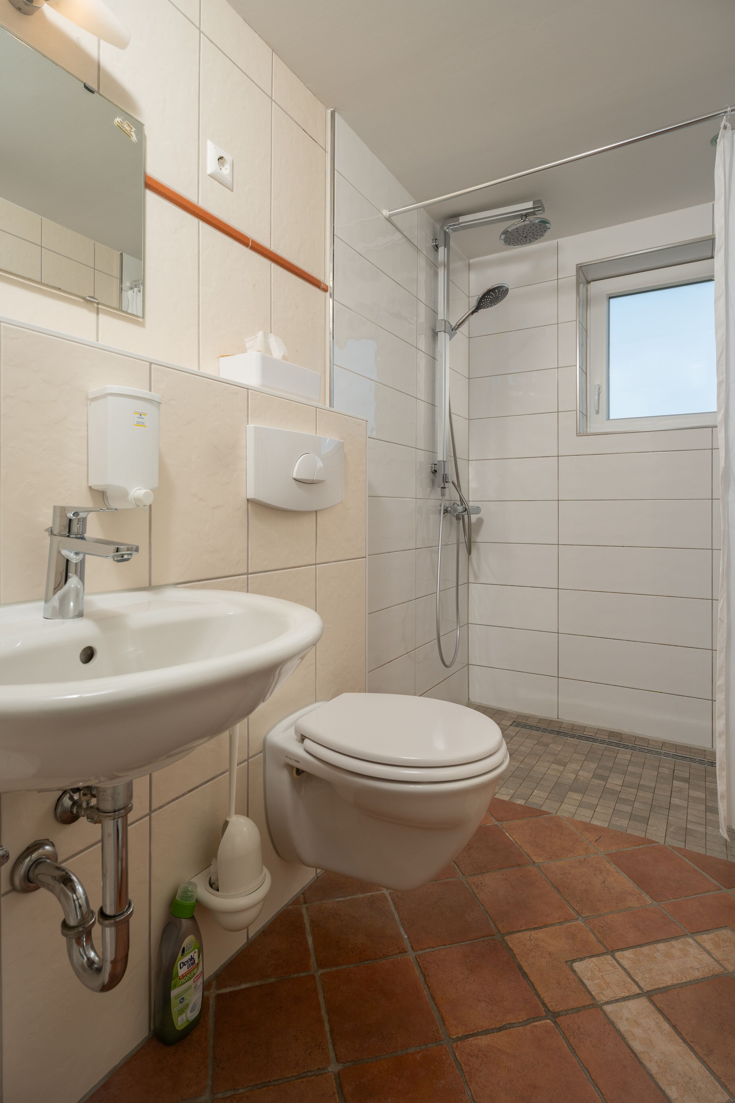 Een badkamer met een wastafel, toilet en douche.