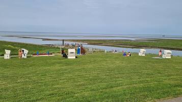 A grassy area with white chairs and a wooden structure with a sign reading "399".