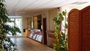 A corridor with a wooden panel on the right, a plant on the left, and a door at the end. - Borda D Agua Apartments (Albufeira)