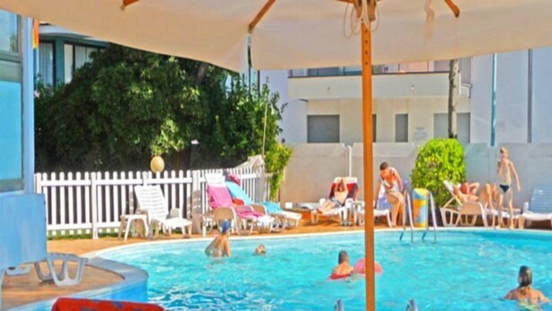 A swimming pool area with lounge chairs and umbrellas. - La Fenice (Jesolo)